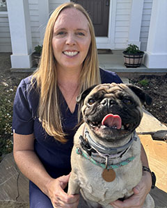 vet with pug dog outside of house